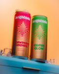Two cans of Brightside drinks, one Strawberry Sunshine and one Guava Glow, on a blue cooler with an orange background.