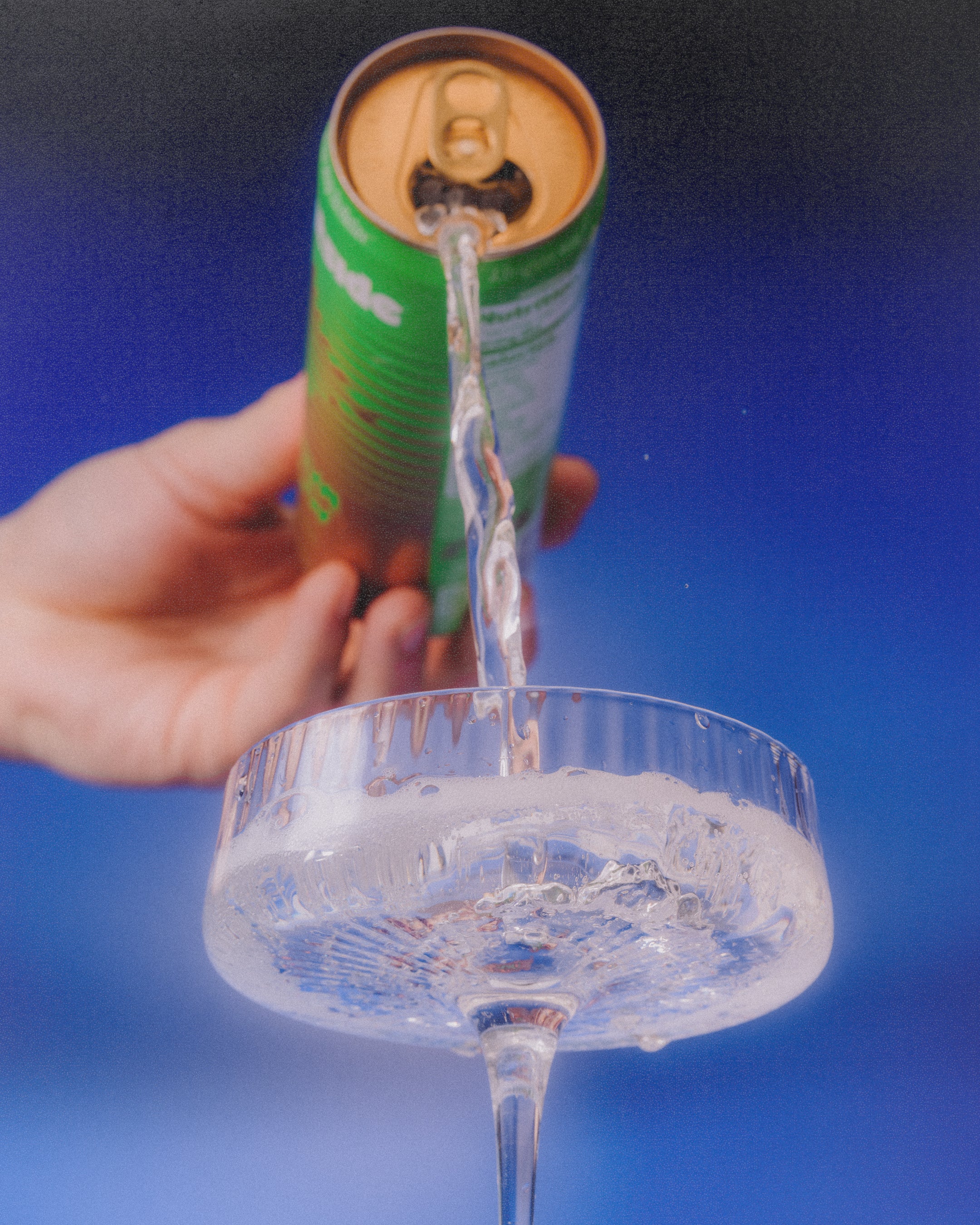 hand pouring can of Guava Glow in drinking glass