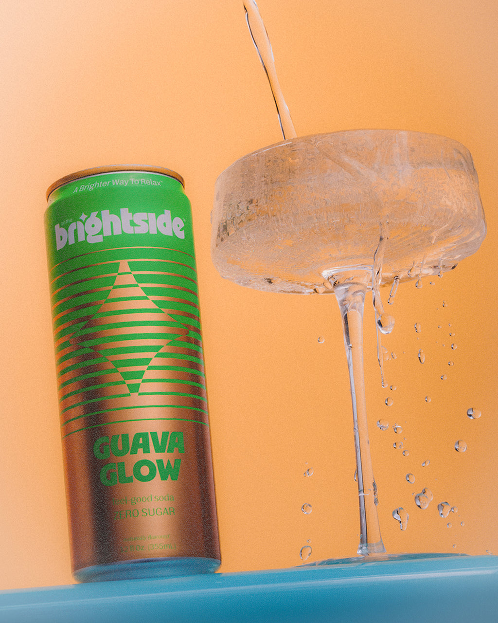 Can of On the Brightside Guava Glow being poured into a glass with ice on an orange background