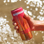 A hand holding a can of Brightside Strawberry Sunshine soda against a sparkling bokeh background.